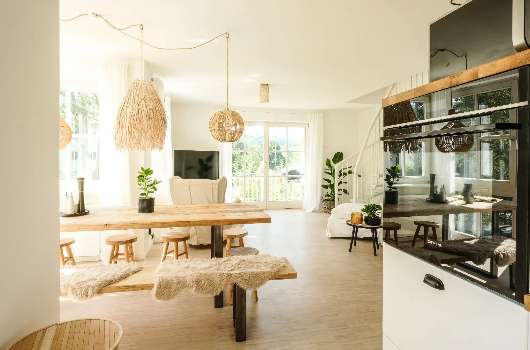 Essbereich mit langem Holztisch, Rattanleuchten und offener Küche