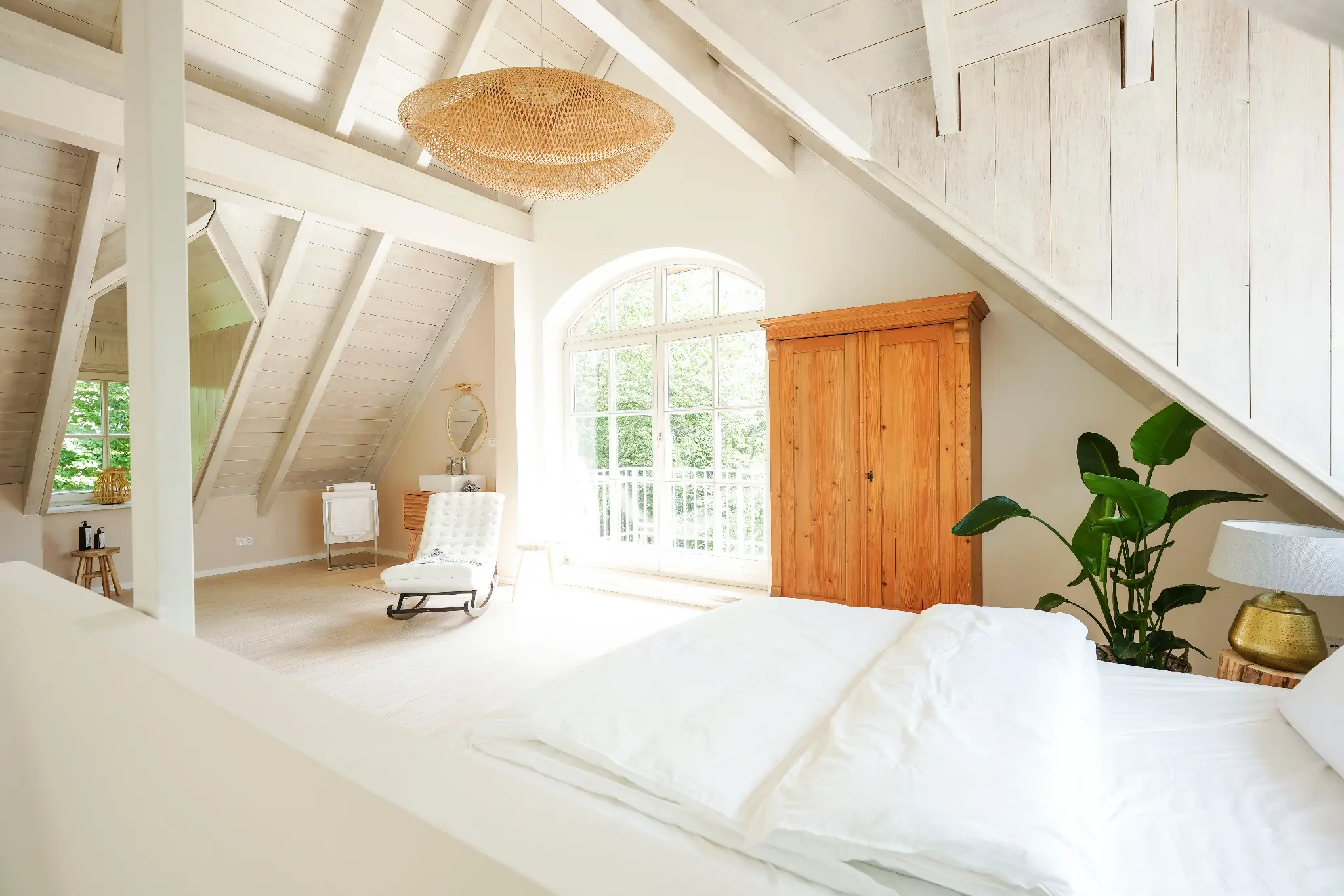 Schlafzimmer mit Doppelbett unter dem Rundbogenfenster
